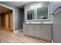 Modern bathroom featuring double sinks with a vanity and a large mirror, complemented by wood-look flooring at 4805 1St Nw St, Lakeland, FL 33810