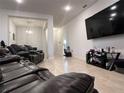 Spacious living room featuring tile floors, large TV and leather furniture set at 499 Meadow Pointe Dr, Haines City, FL 33844