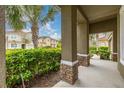 Inviting front porch with brick accents and lush greenery, offering a warm welcome at 5411 Oakgrain Ct, Davenport, FL 33837