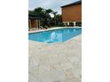 Community pool with lounge chairs and well maintained tile deck at 6013 Westgate Dr # 2421, Orlando, FL 32835