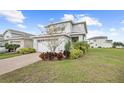 Beautiful, two-story home with a brick driveway, lush landscaping, and an attached two-car garage at 6699 Alder Rd, Harmony, FL 34773