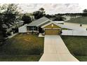 Elevated home view features manicured lawn, white fence, and long driveway at 881 Hudson Valley Dr, Kissimmee, FL 34759