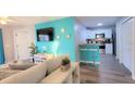 Open floor plan with a bright turquoise accent wall and a breakfast bar to the kitchen at 8824 Grand Palms Cir # A, Kissimmee, FL 34747