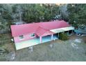 An aerial view showcases this single-story home with covered porch, a carport and expansive yard at 912 Ne 144Th Ct, Silver Springs, FL 34488