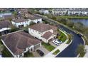 An aerial view shows homes with tile roofs, green lawns, and a community with a tranquil lake at 10902 Citron Oaks Dr, Orlando, FL 32836