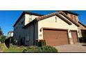 Exterior side view of a home showing the 2-car garage and brick driveway at 10902 Citron Oaks Dr, Orlando, FL 32836