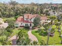 Beautiful aerial view of the property showcasing the home's red tile roof, mature landscaping, and brick driveway at 1211 Aquila Loop, Kissimmee, FL 34747