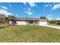 Charming single-story home features a stone-accented facade, a well-manicured lawn, and a spacious two-car garage at 1240 Beth Ln, St Cloud, FL 34772