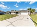 Charming single-story home with an inviting exterior, a well-manicured lawn, and a long driveway at 1240 Beth Ln, St Cloud, FL 34772