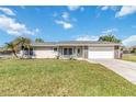 Charming single-story home features a stone-accented facade, a well-manicured lawn, and a spacious two-car garage at 1240 Beth Ln, St Cloud, FL 34772