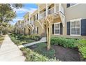 Exterior view of townhomes with small balconies, landscaped yards and sidewalks at 1343 Flagstone Ave, Celebration, FL 34747