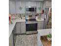 Well-lit kitchen featuring stainless steel appliances, gray cabinets, and stylish backsplash at 1422 Indiana Ave, St Cloud, FL 34769