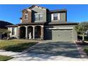 Charming two-story home featuring stone accents, a two-car garage, and a well-manicured lawn at 1820 Trophy Bass Way, Kissimmee, FL 34746