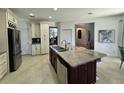Open kitchen with a center island, stainless steel appliances, and custom cabinetry for ample storage at 1966 Derby Glen Dr, Orlando, FL 32837