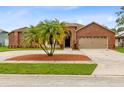 Charming brick home with a circular driveway, mature palm trees, and an attached two-car garage at 2408 Sweetwater Blvd, St Cloud, FL 34772