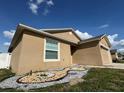 Charming single-story home with beige stucco exterior and decorative rock landscaping at 299 Chicago W Ave, Haines City, FL 33844