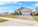 Exterior view of a well-maintained home with a brick driveway and manicured lawn in a suburban neighborhood at 33436 Country House Dr, Sorrento, FL 32776