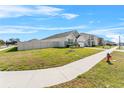 Neighborhood street view showcasing sidewalks, green spaces, and neighboring houses, fostering a community feel at 33436 Country House Dr, Sorrento, FL 32776