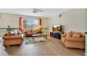 Comfortable living room featuring hardwood floors, a ceiling fan, and large windows for natural light at 3452 Goldeneye Ln, St Cloud, FL 34772