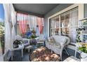 Charming covered porch with white wicker furniture and decorative curtains at 3741 Crossing Creek Blvd, St Cloud, FL 34772