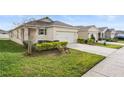 A cozy single-story home with a two-car garage and a well-kept lawn at 444 Lily Ln, Davenport, FL 33837