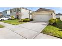 Well-manicured front yard of a single-story house featuring a two-car garage at 444 Lily Ln, Davenport, FL 33837