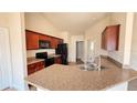 Bright kitchen with brown cabinets, black appliances, and a pass-through to dining area at 553 Viceroy Ct, Kissimmee, FL 34758