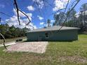 View of the home showcasing a brick patio and a green lawn at 6430 Sw 144Th Street Rd, Ocala, FL 34473