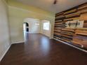 Spacious living room with an archway, dark wood floors, and an accent wall at 713 Illinois Ave, St Cloud, FL 34769