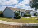 Exterior view of a light-blue single-story home with a well-maintained lawn and inviting curb appeal at 790 Greenshank Dr, Haines City, FL 33844
