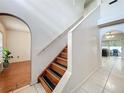 Bright entryway featuring a staircase, arched doorways, and tile and wood flooring at 10409 Laxton St, Orlando, FL 32824