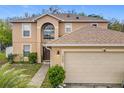 Charming two-story home featuring a two-car garage, manicured lawn, and classic architectural details at 10409 Laxton St, Orlando, FL 32824
