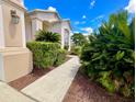 Inviting walkway leading to the home, bordered by mature landscaping and lush greenery at 106 Southern Pine Way, Davenport, FL 33837