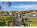 Wooden dock featuring an outdoor gazebo sitting on a lake at 10919 Lakeshore Dr, Clermont, FL 34711