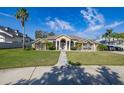 Beautiful home with lush front lawn, mature palms, and inviting walkway to the front door at 10919 Lakeshore Dr, Clermont, FL 34711