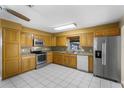 Functional kitchen with stainless steel appliances, ample cabinet space, and white tile flooring at 1506 Maryland Ave, St Cloud, FL 34769