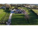 Aerial view of a home with a large lawn and a driveway leading up to the house at 15350 Arabian Way, Montverde, FL 34756