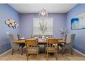 Stylish dining room with blue walls, a modern light fixture and a wooden table at 1909 Nice Ct, Kissimmee, FL 34747