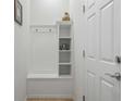 Charming entryway featuring a white storage bench, coat hooks, and a decorative shelf at 1909 Nice Ct, Kissimmee, FL 34747