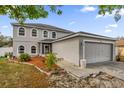 Two-story home featuring a two-car garage, landscaped yard, and covered front entry at 241 Cranbrook Dr, Kissimmee, FL 34758