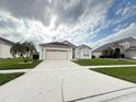 Inviting single-story home with a two-car garage, attractive landscaping, and a spacious driveway at 2577 Aster Cove Ln, Kissimmee, FL 34758