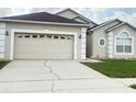 Close-up of the property's two-car garage, showing the driveway and adjacent landscaping details at 2577 Aster Cove Ln, Kissimmee, FL 34758