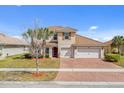 Beautiful two-story home with a tile roof, spacious driveway, and a manicured lawn at 3723 Isles Arbor Ln, Kissimmee, FL 34746