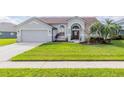 Single-story home with manicured lawn, two-car garage, and a welcoming entryway at 4119 Maidu Ct, St Cloud, FL 34772