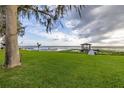 Scenic waterfront view showcasing a well-maintained lawn and dock with boat lift at 4815 Cypress Dr, Lake Wales, FL 33898