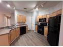 Kitchen featuring wood cabinets, black appliances, laminate countertops and grey flooring at 501 Terrace Ridge Cir # 501, Davenport, FL 33896