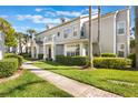 A well-maintained townhouse exterior with beautiful landscaping and sidewalk at 5025 Wellington Park Cir # 68, Orlando, FL 32839