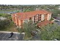 Aerial view of condo buildings showcasing red tiled roofs, exterior balconies, and the surrounding landscape and parking at 5560 Metrowest Blvd # 304, Orlando, FL 32811