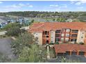 Aerial view of condo buildings showcasing red tiled roofs, exterior balconies, and the surrounding landscape and parking at 5560 Metrowest Blvd # 304, Orlando, FL 32811