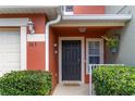 Close up of front door featuring a black door, potted plants, manicured landscaping, and a cozy front entrance at 565 Cresting Oak Cir # 87, Orlando, FL 32824